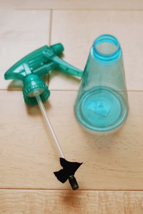 botella de spray con bomba bloqueada por un paño negro