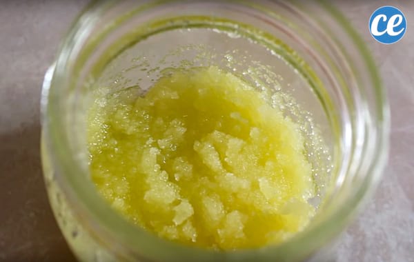 Mezcla de azúcar, aceite de oliva y jugo de limón en un recipiente de vidrio para exfoliar la piel de los pies.