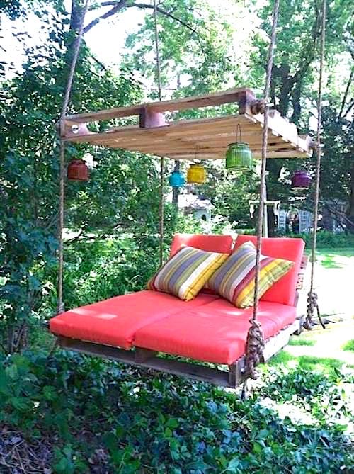 Una cama columpio roja hecha de palet de madera.