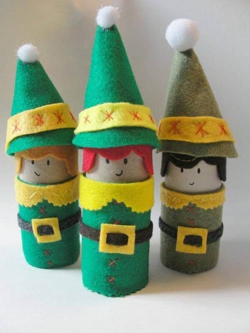 3 elfos verdes hechos con rollos de papel higiénico con sombreros y abrigos