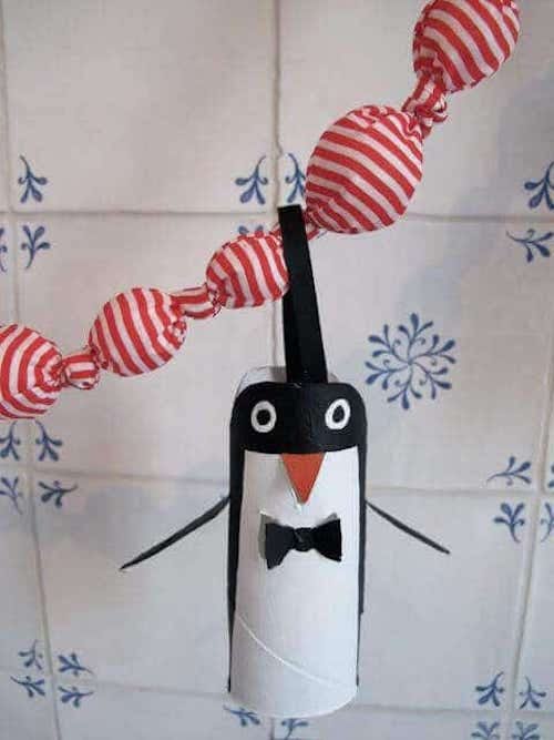 pingüino colgante hecho con un rollo de PQ