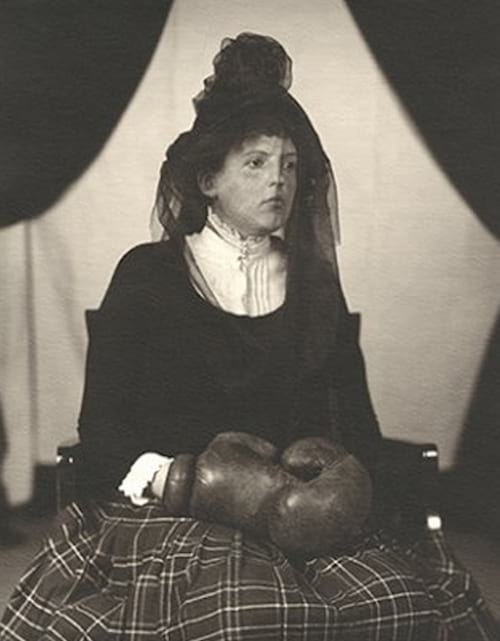 Mujer sentada en una silla equipada con guantes de boxeo