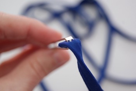 use un cordón para enhebrar un elástico a través de un dobladillo