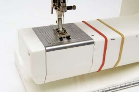 Coloque una banda de goma alrededor de la base de su máquina de coser para guiarlo cuando haga dobladillos.