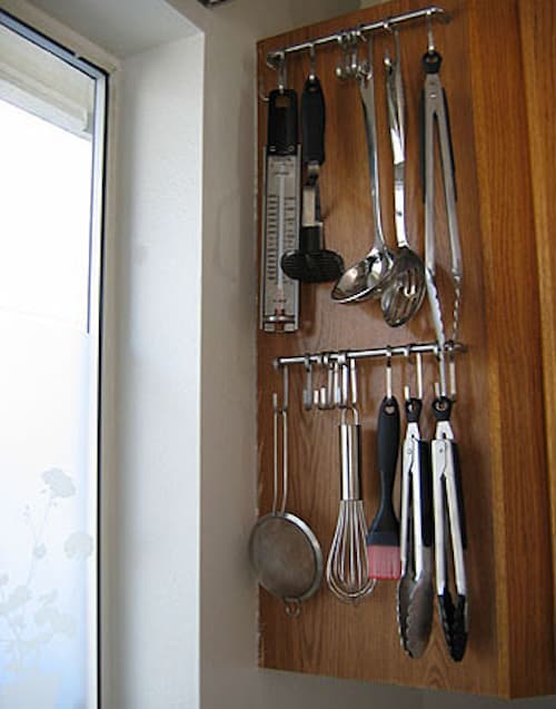 Un gran consejo de almacenamiento es usar barras y ganchos para guardar los utensilios de cocina.