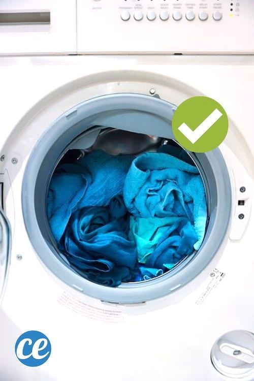 Una lavadora cargada de ropa sucia.
