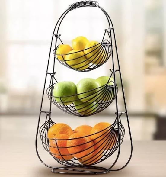 Una cesta de frutas de metal de tres niveles.