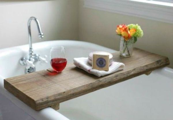 Una tabla de madera que sirve como bandeja en una bañera.