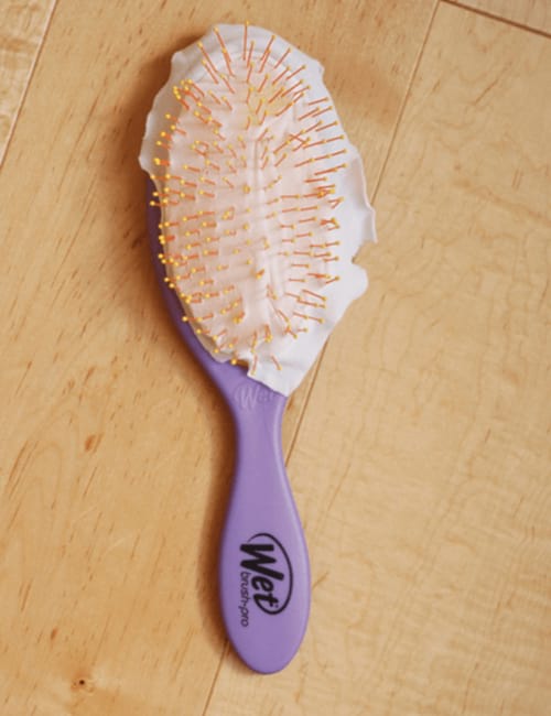 Un cepillo para el cabello con un trozo de nailon para facilitar la limpieza.