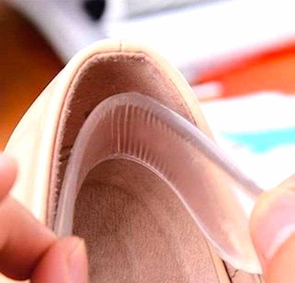 हाथ जो जूते के अंदर एक सिलिकॉन पैड डालते हैं।