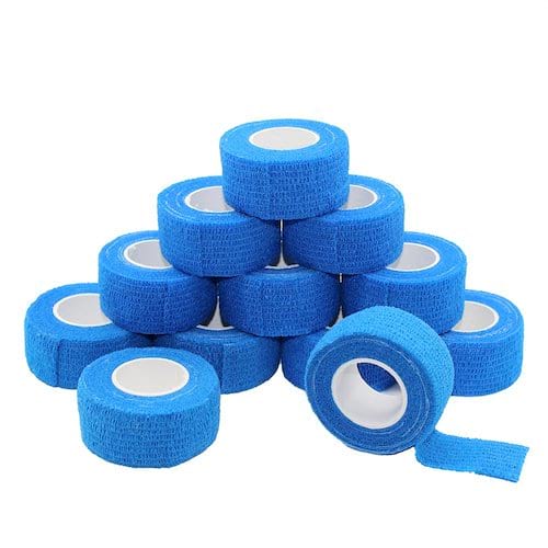 Rollos de cinta adhesiva médica azul sobre un fondo blanco.