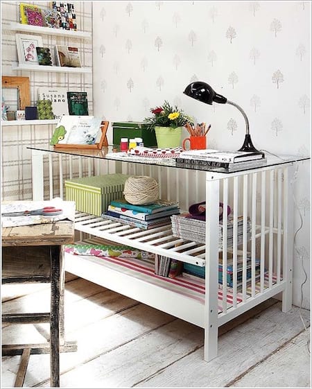 Un llit per a nadons blanc transformat en una taula o escriptori per a adults