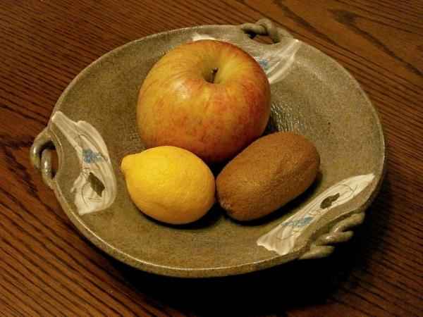 cup with seasonal fruits: apples, kiwis, lemon