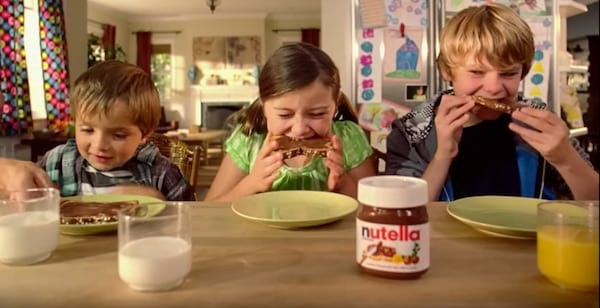 Niños comiendo tostadas de nutella en el desayuno