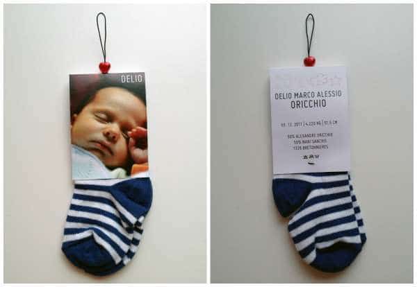 una tarjeta de anuncio de nacimiento con un calcetín de bebé