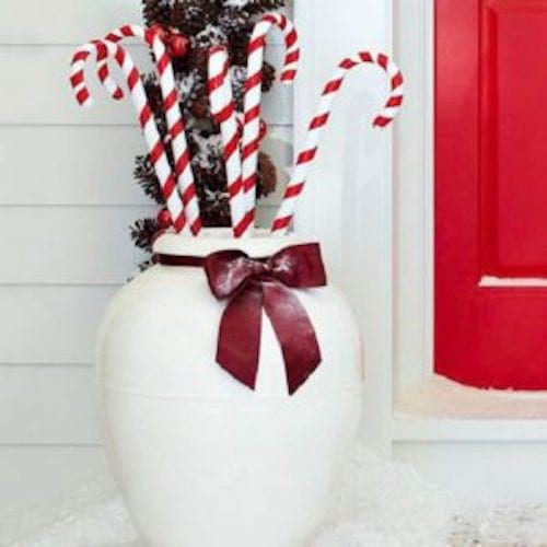 Grandes bastones de caramelo rojos y blancos en un enorme jarrón blanco