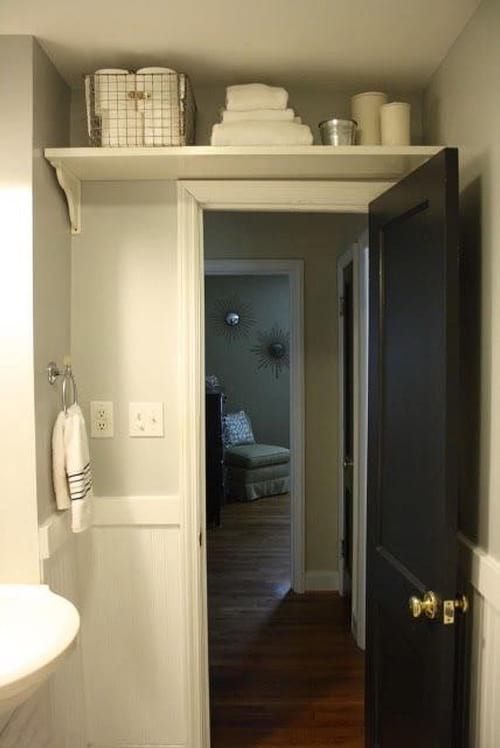 Un estante colocado encima de la puerta del baño para guardarlo.