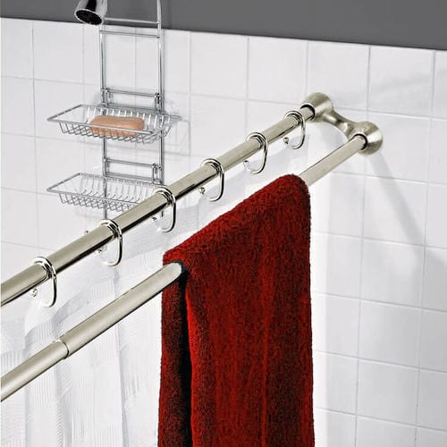 Una barra de cortina doble para poner también las toallas a secar en el baño