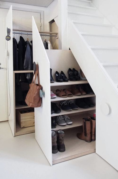 un armario debajo de las escaleras para guardar abrigos y zapatos