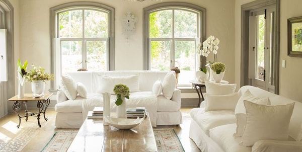 Sala de estar llena de muebles blancos con un aspecto simple.
