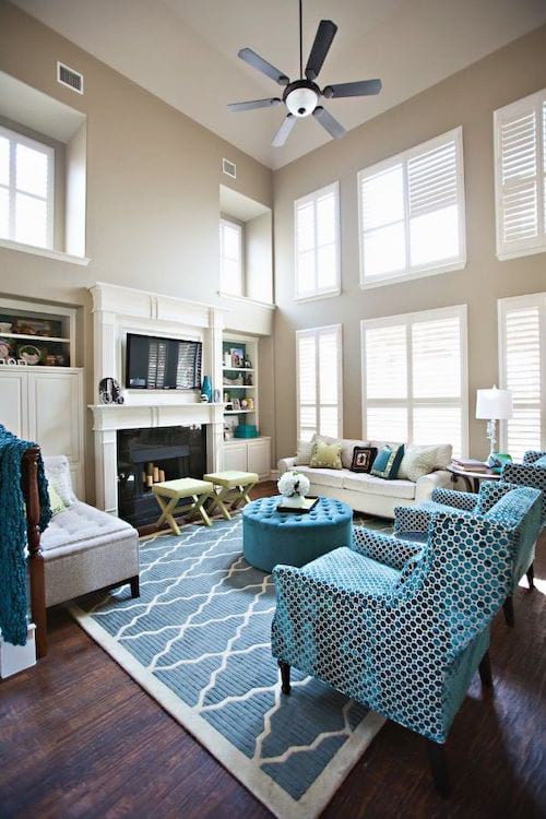 Sala de estar con paredes teñidas de beige y muebles azules.