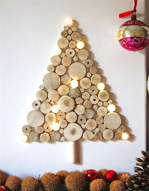 Et juletræ lavet med træstammer og oplyste guirlander