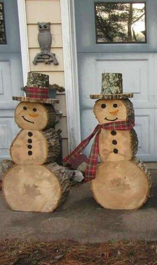 Dos ninot de neu a l'aire lliure fets amb troncs de fusta