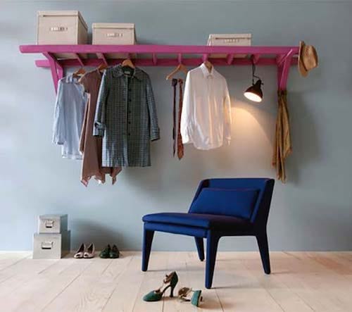 Pink ladder hung horizontally on the wall for clothes