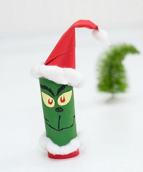 Hombrecito grinch hecho de rollo de papel higiénico pintado de verde y decorado