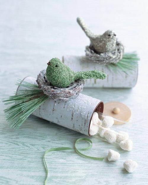 2 slikposer lavet med toiletpapirruller dekoreret med en rede og en fugl