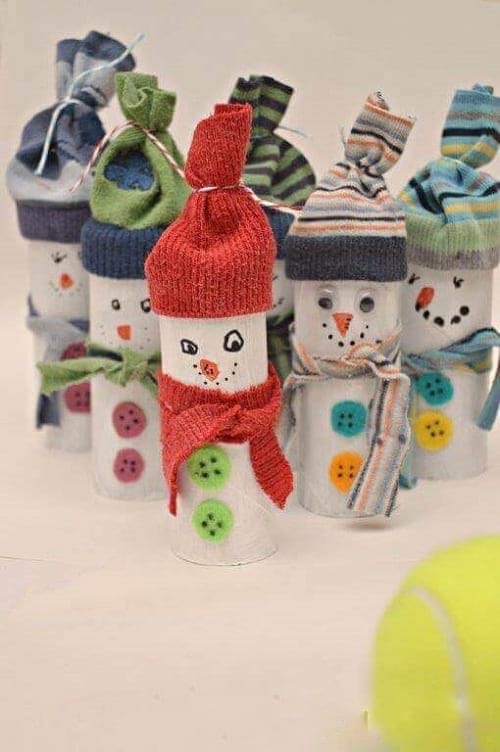 אנשי שלג קטנים לבושים לחורף עם כובעים וצעיפים עשויים מגלילי נייר טואלט