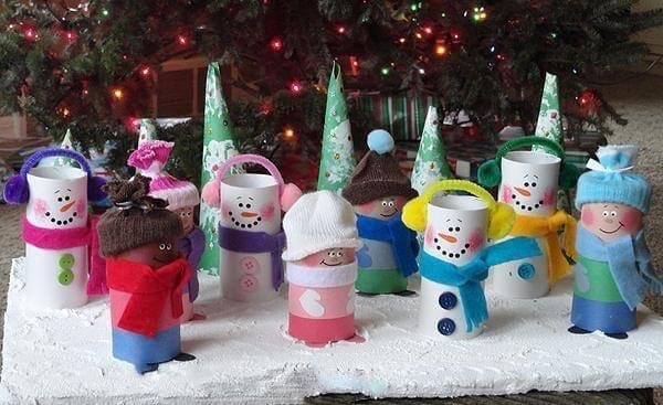 Escena navideña con personajes y muñeco de nieve hecho con rollos de papel higiénico.
