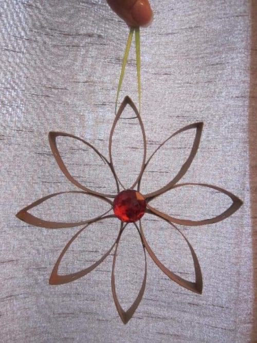 Una flor hecha con un rollo de papel higiénico para decoración navideña