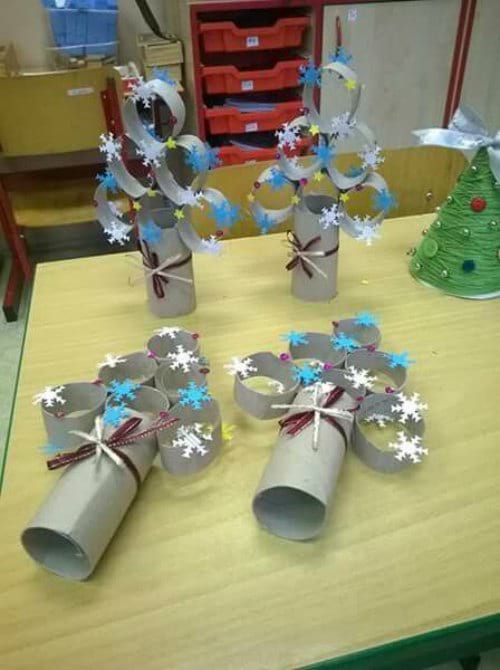Árboles de Navidad hechos con rollos de papel higiénico en rodajas pintados de azul