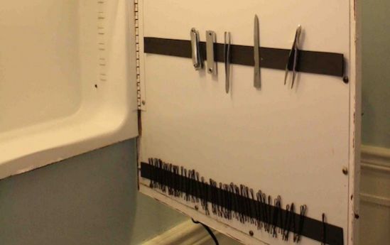 almacenamiento inteligente con una barra magnética pegada a la puerta del armario del baño