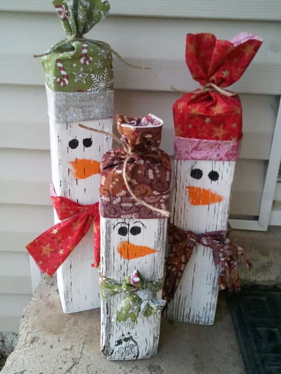 troncos decorados como un muñeco de nieve