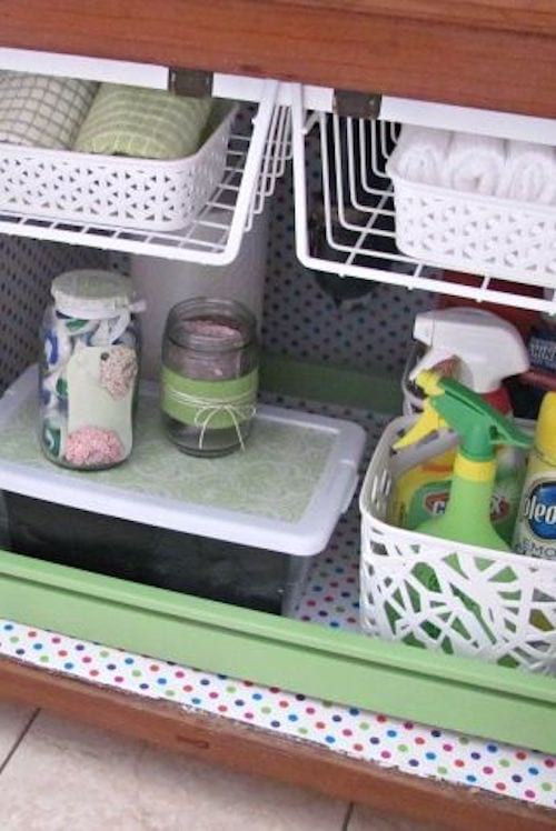 Cajón verde con varios objetos guardados en su interior y cestas blancas que sirven de almacenaje