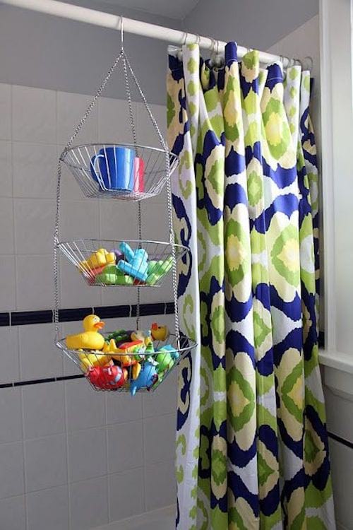 Tres cestas escalonadas que cuelgan de una cortina de ducha que sirve como almacenamiento