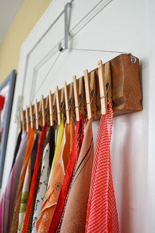 Alfileres de ropa colgados en la pared y utilizados como soporte de accesorios.