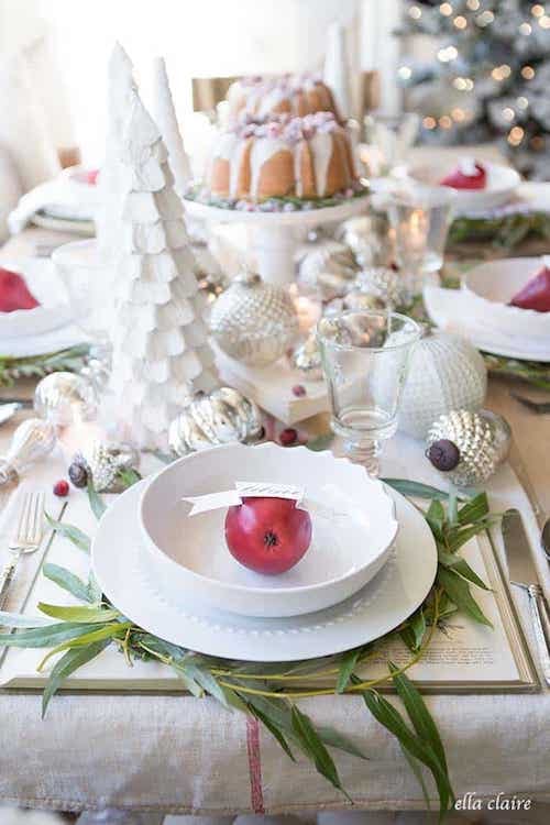 كل طاولة بيضاء مزينة بتفاحة حمراء على طبق