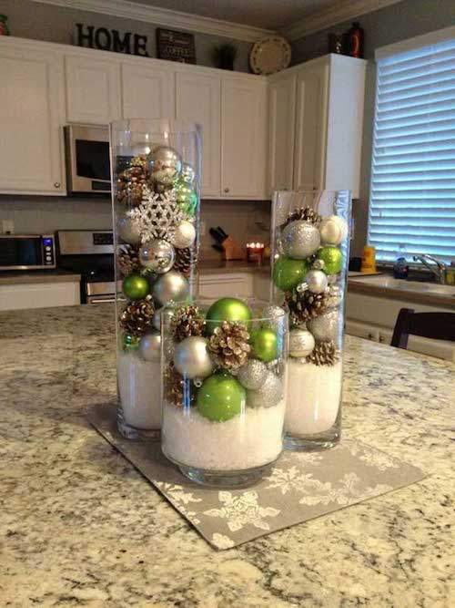 हरे और भूरे रंग की गेंदों और बर्फ के साथ पारदर्शी फूलदान