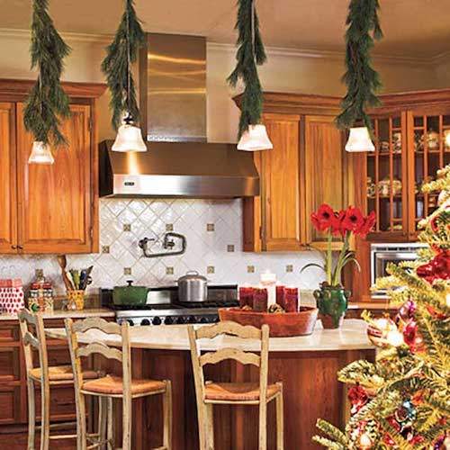 Guirnaldas de navidad verde colgando de las lámparas de la cocina