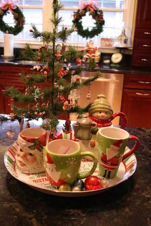 Árbol de Navidad en medio de la cocina con tazas.