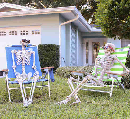 esqueletos sentados en el jardín para halloween
