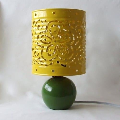 Una lata decorada y cortada en amarillo para formar una lámpara.