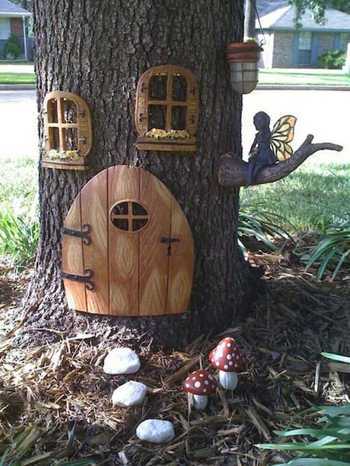 una casa de fades en un tronc d'arbre per decorar el jardí