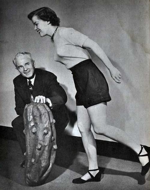 Hombre sujetando una especie de pepinillo gigante en el suelo junto a una mujer