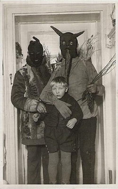 Dos hombres con pasamontañas negros sosteniendo a un niño