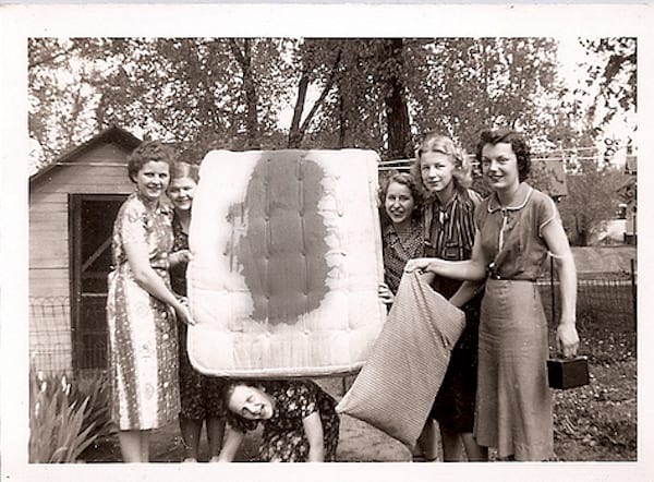 Varias mujeres sosteniendo un colchón y otros objetos.