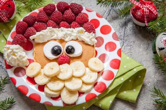 en julemand til morgenmad lavet med en pandekage og frugt